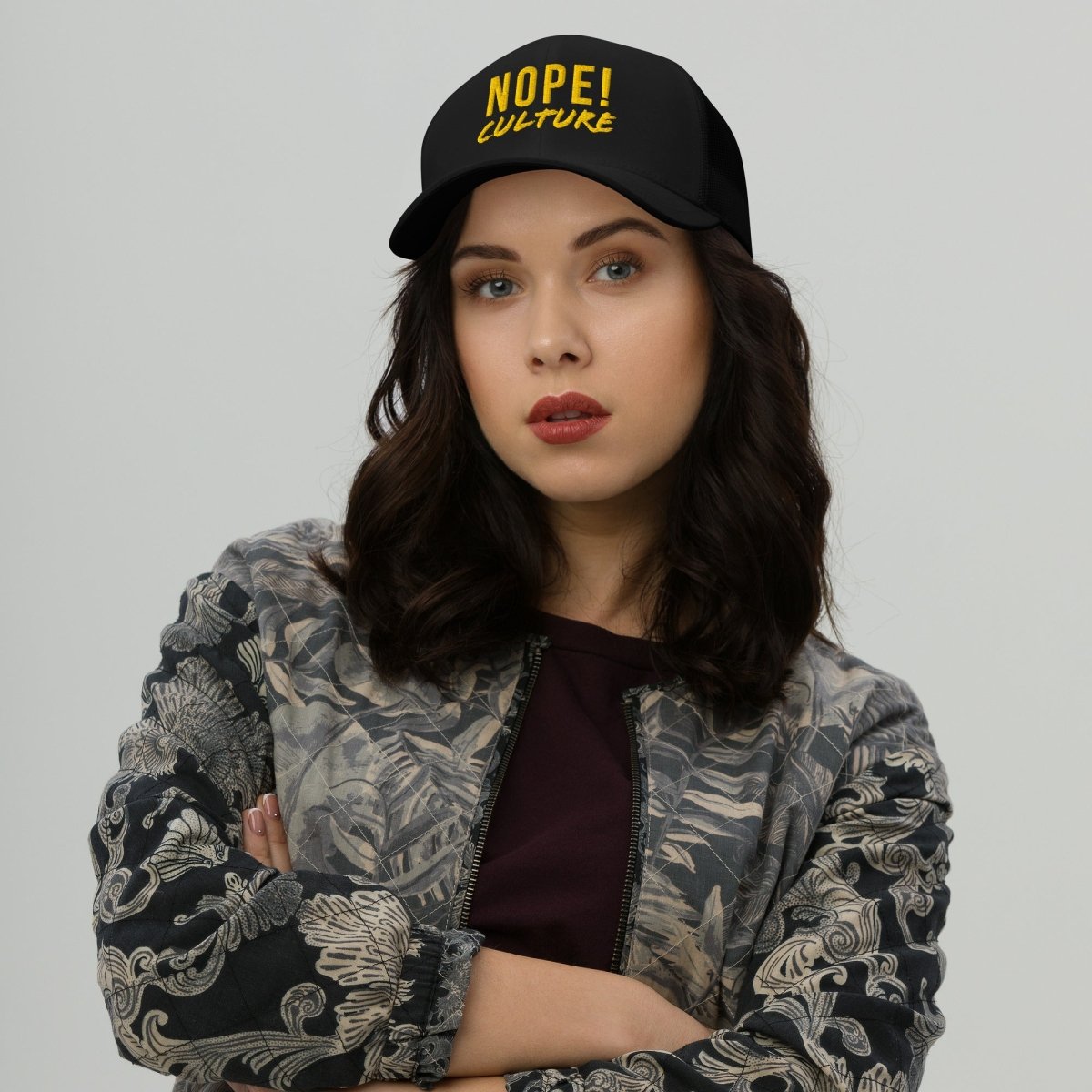 Woman wearing black NOPE! Culture trucker cap with bold yellow writing