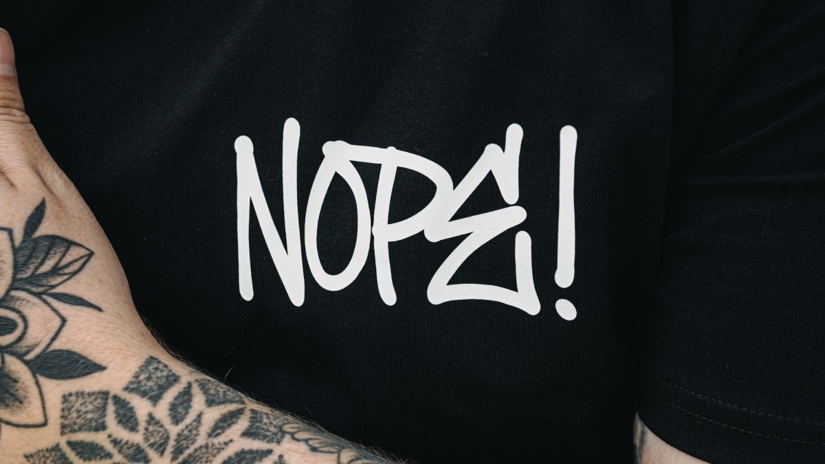 Close up of NOPE! logo on cotton T Shirt